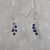 A pair of blue chainmail beaded earrings with six pearly blue glass seed beads per earring, connected by silver-colored jump rings and finished with sterling silver earring hooks.