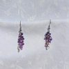 A pair of handmade earrings featuring a cascading blend of purple and white glass seed beads, connected by steel-colored jump rings and hooks.