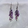 A pair of handmade earrings featuring cascading blend of purple and white glass seed beads, connected by steel-colored jump rings and hooks.