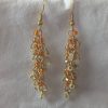 Orange Creamsicle earrings featuring 27 beads in gold-lined opal, matte orange, and gold-lined clear, linked with gold-colored jump rings and matching hooks.