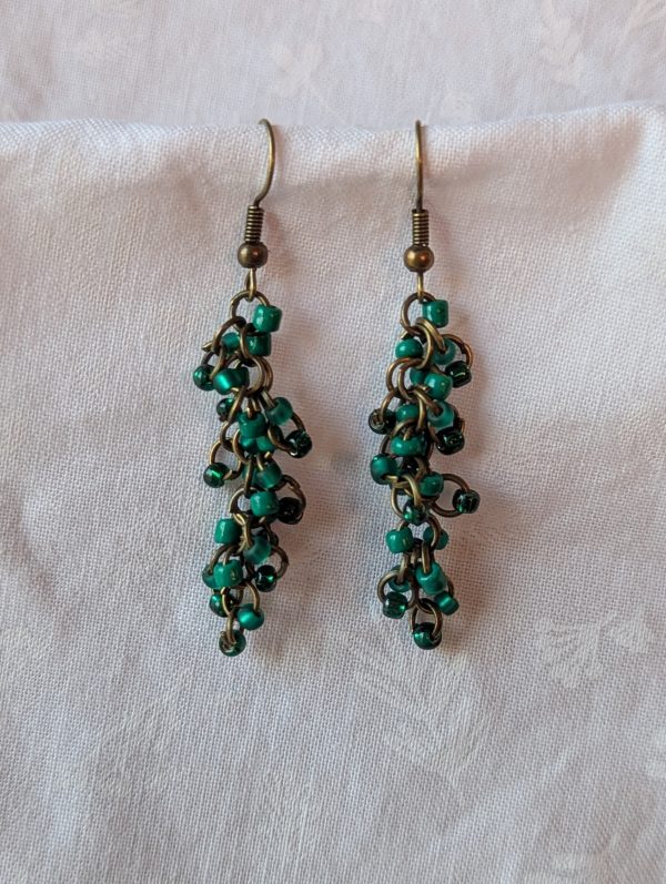Emerald City earrings with 27 beads in solid green, matte green, and silver-lined green, connected with bronze-colored jump rings and matching earring hooks.
