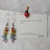 A pair of handmade dangle earrings featuring 24 transparent glass beads in rainbow colors, hanging from silver-colored jump rings and earring hooks.
