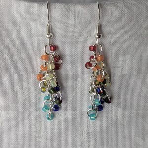 Handmade Gilded Prism Earrings featuring 18 pearly and metallic-lined glass beads in red, orange, yellow, green, deep blue, and capri blue, with silver-colored jump rings and hooks.