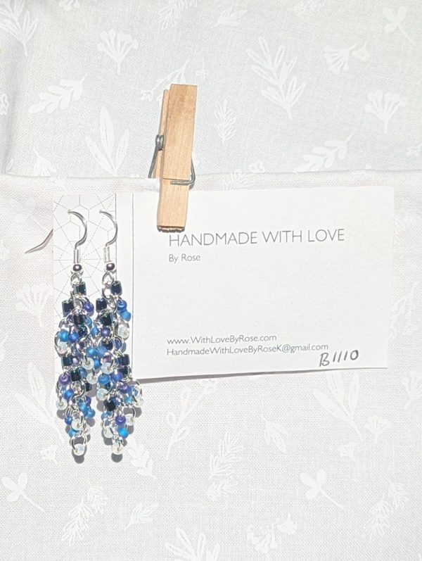 Celestial Veil: Handmade earrings with 36 seed beads in iridescent indigo, purple, blue, and gold-lined white, connected by silver jump rings and hooks.