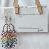 Radiant Cascade earrings with colorful rainbow beads hanging from silver-toned chandelier ornaments, connected by steel-colored jump rings and matching hooks.