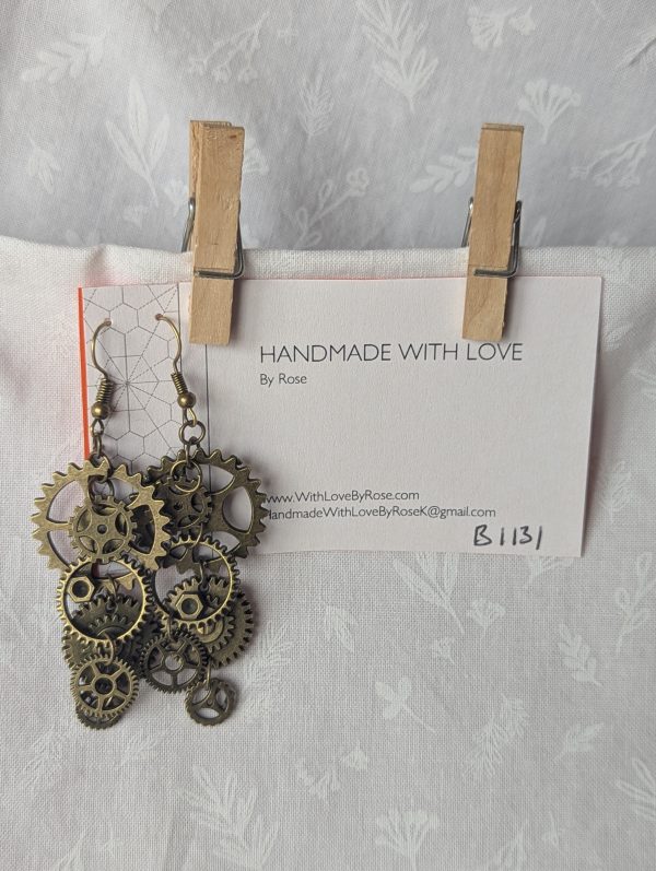 The Clockwork Dreams Earrings: bronze gear earrings featuring six metal gears linked with bronze jump rings and matching bronze earring hooks.