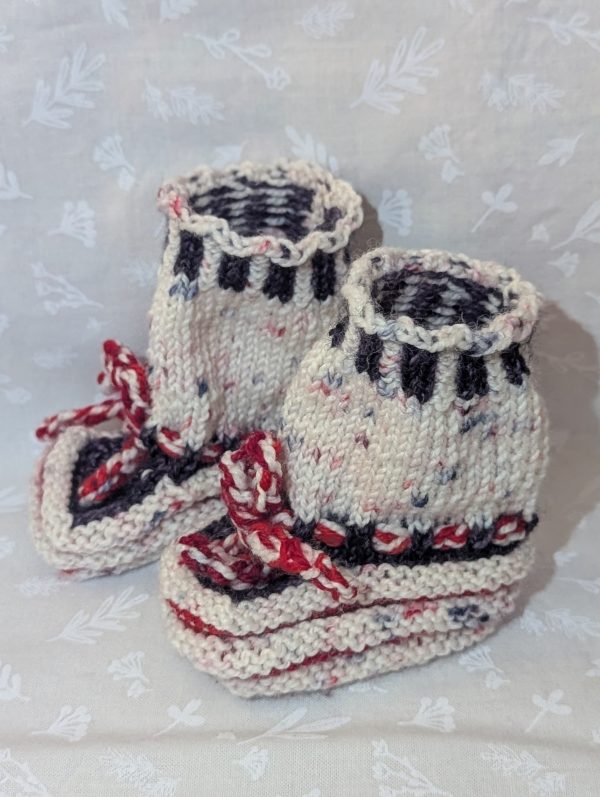 Peppermint Cream Holiday Baby Booties: Cream and brown handknit baby booties with red-and-white twisted ties, perfect for holiday newborns.