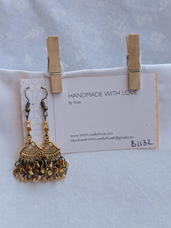 Desert Dusk Earrings: Antiqued gold chandelier-style earrings with 30 beads in silver-lined brown, silver-lined tan, and pearly beige, finished with bronze-colored hooks.