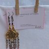 Gilded Ruby Cascade Earrings: Antiqued gold filigree earrings with five cascading bronze chains, each adorned with red-toned beads in multiple textures and finishes.