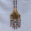 Gilded Ruby Cascade Earrings: Antiqued gold filigree earrings with five cascading bronze chains, each adorned with red-toned beads in multiple textures and finishes.