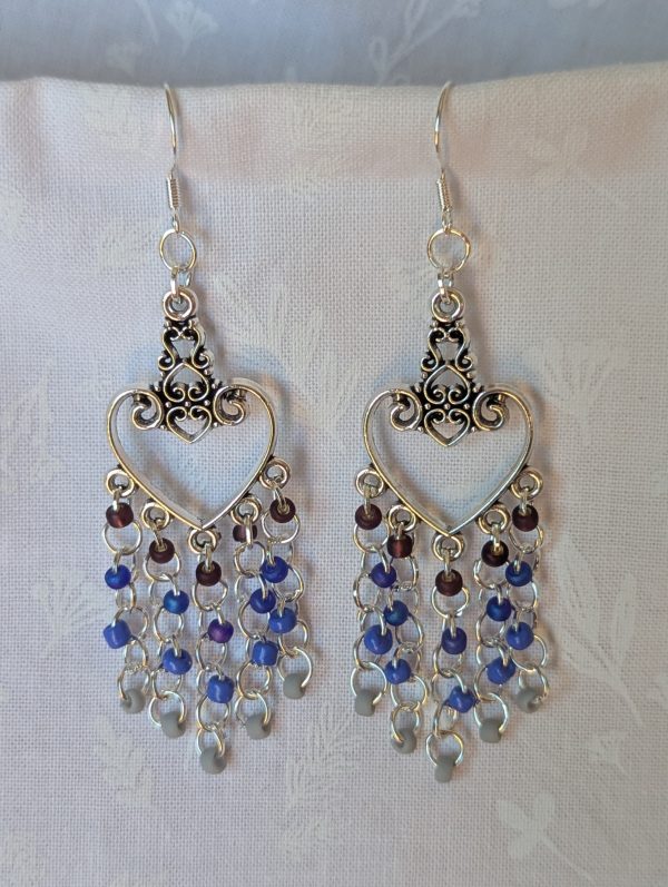 Twilight Romance Earrings: Pair of silver-colored heart earrings with intricate filigree tops and 20 dangling glass beads in deep red, blue, violet-blue, and frosted gray.
