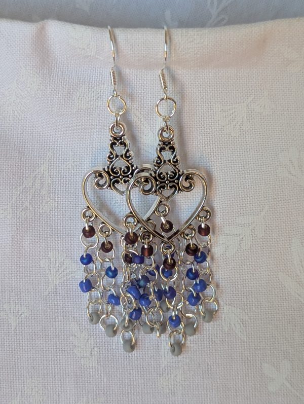 Twilight Romance Earrings: Pair of silver-colored heart earrings with intricate filigree tops and 20 dangling glass beads in deep red, blue, violet-blue, and frosted gray.