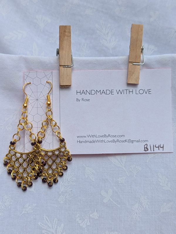 Gilded Wine Earrings: Gold-colored earrings with 11 burgundy red glass beads featuring gold lining, hung from antique gold ornaments.