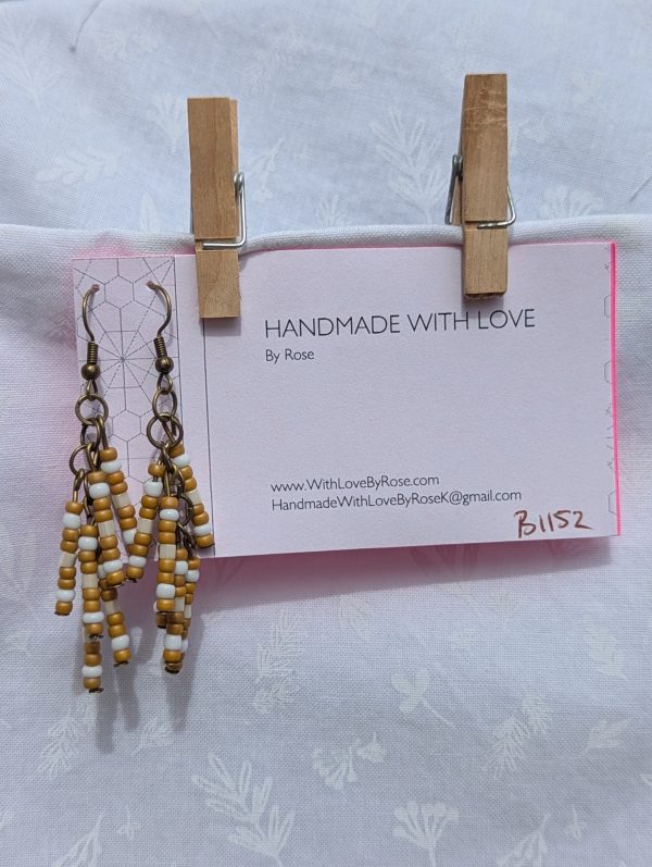 Sandswept Glow — Earrings with earthy tan, ivory white, and pearlescent cream glass beads on bronze-toned posts and hooks.