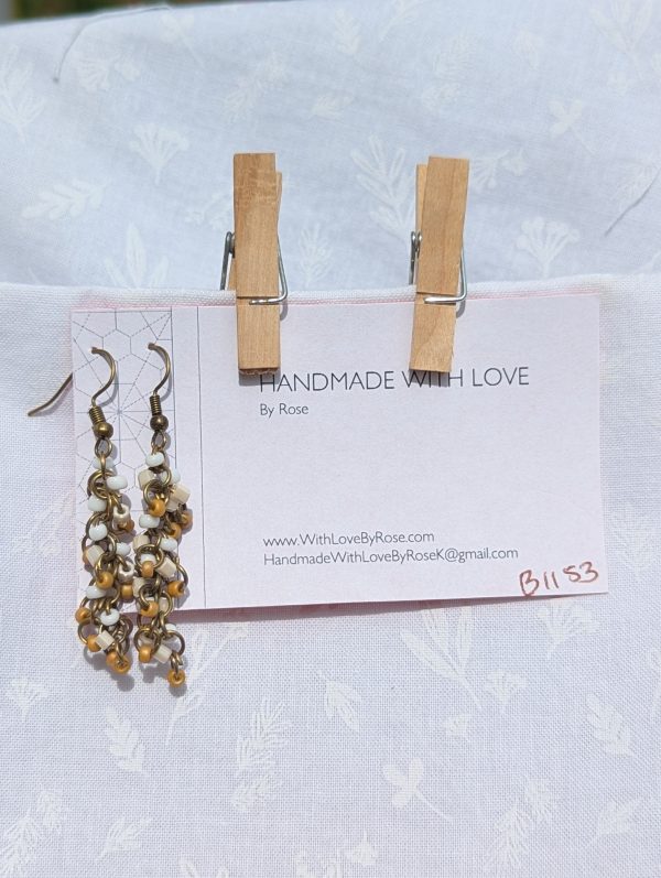 Sandswept Cascade Earrings: Earrings with earthy tan, ivory white, and pearlescent cream glass beads on bronze-toned jump rings with matching hooks.