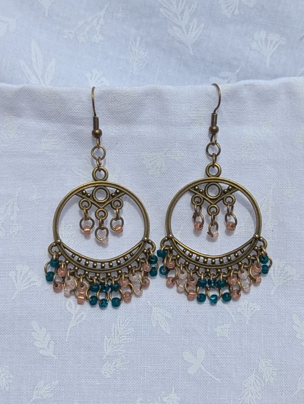 Twilight Oasis — Bronze Tibetan-style earrings with 25 glass beads in frosted teal, silver-lined teal, pale pink, and rose pink.