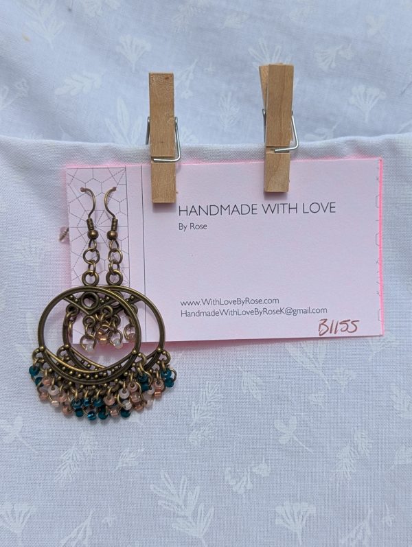 Twilight Oasis — Bronze Tibetan-style earrings with 25 glass beads in frosted teal, silver-lined teal, pale pink, and rose pink.