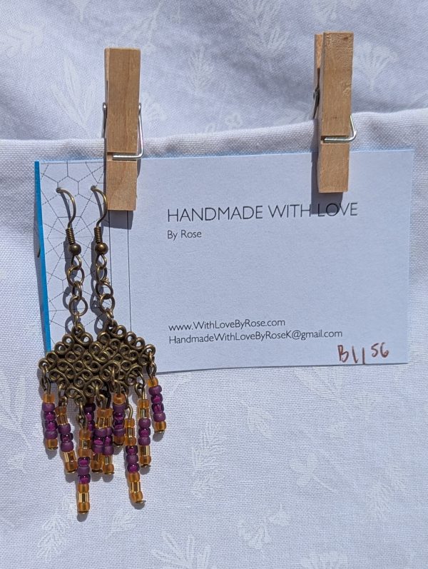 Saffron Twilight — Handmade bronze Tibetan-style earrings with 35 glass beads in plum, mulberry, gold-lined, and amber-gold tones.