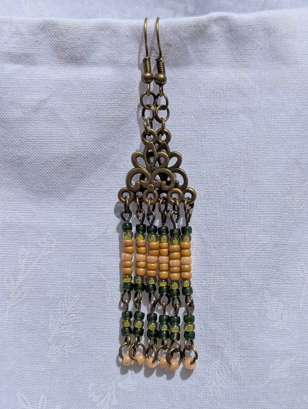 Verdant Bloom — Bronze chandelier earrings with floral Tibetan-style ornaments and dangling strands of amber, forest green, pale yellow, and ivory glass beads.