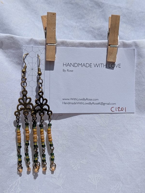 Verdant Bloom — Bronze chandelier earrings with floral Tibetan-style ornaments and dangling strands of amber, forest green, pale yellow, and ivory glass beads.