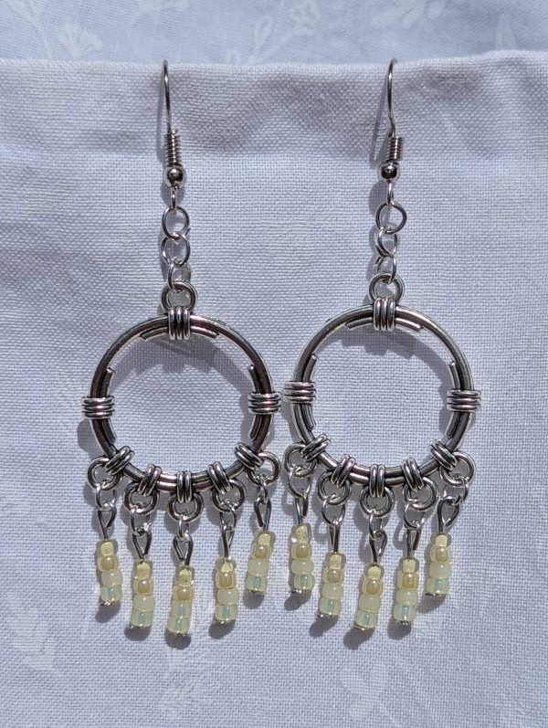 Lemon Meringue Glow — Silver hoop earrings with wrapped detailing and dangling pale yellow and champagne-toned glass beads in soft, translucent shades.