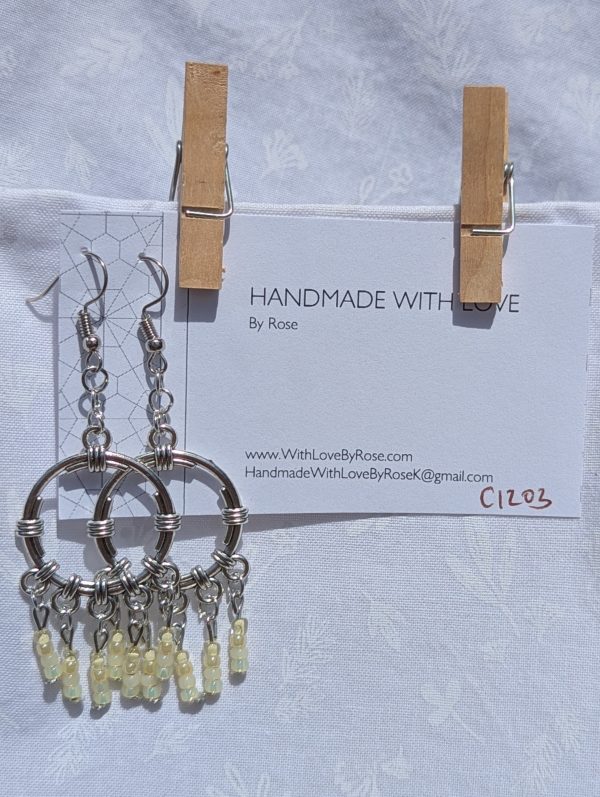Lemon Meringue Glow — Silver hoop earrings with wrapped detailing and dangling pale yellow and champagne-toned glass beads in soft, translucent shades.