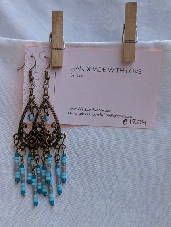 Winter Garden Earrings — Bronze teardrop earrings with floral filigree and dangling strands of glacier blue, sky blue, gray, and turquoise glass beads.