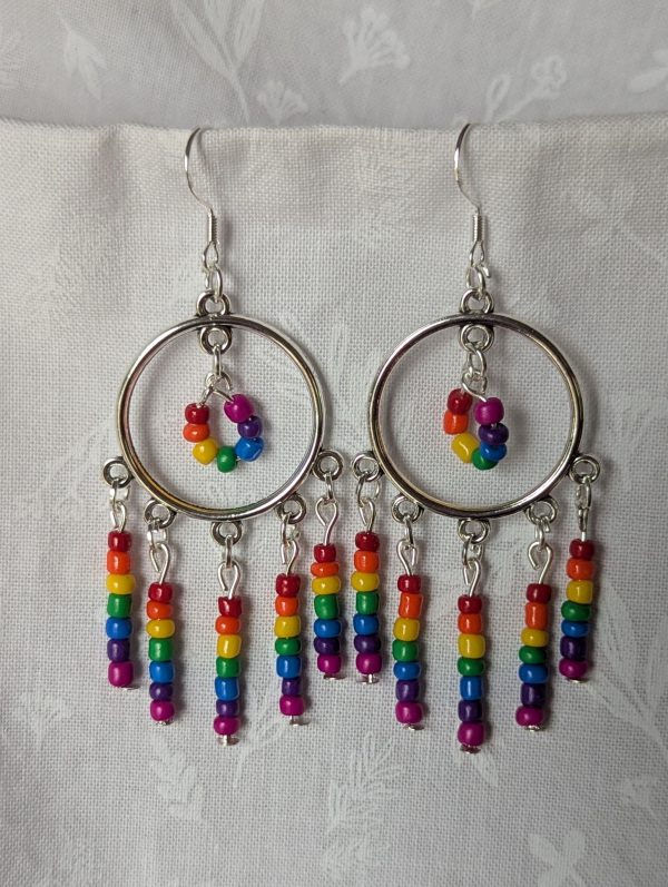 Rainbow circle earrings with silver hoops, five dangling rainbow strands, and a circular rainbow bead charm in the center.
