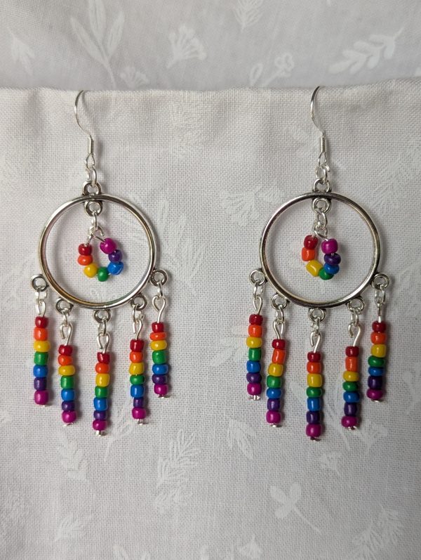 Rainbow circle earrings with silver hoops, five dangling rainbow strands, and a circular rainbow bead charm in the center.