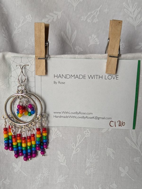 Rainbow circle earrings with silver hoops, five dangling rainbow strands, and a circular rainbow bead charm in the center.