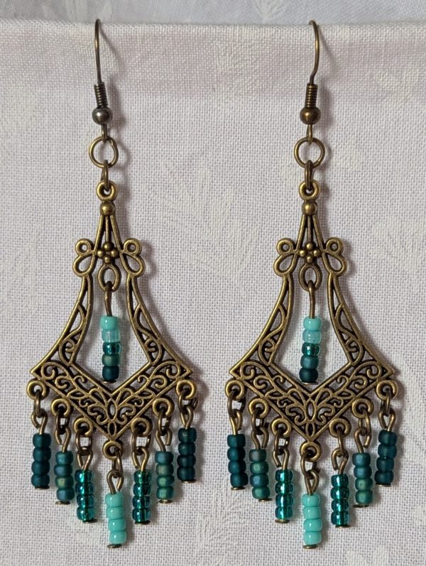 Teal Twilight Earrings with 29 teal glass beads in four ocean-inspired hues, hanging from ornate bronze filigree ornaments and bronze hooks.