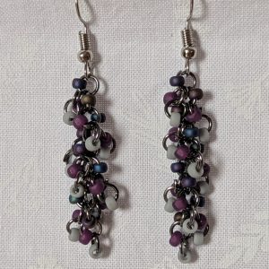 Shadow Galaxy Earrings with 27 beads in matte gray, frosted plum, and iridescent galaxy tones, linked with tungsten-colored rings and steel hooks.