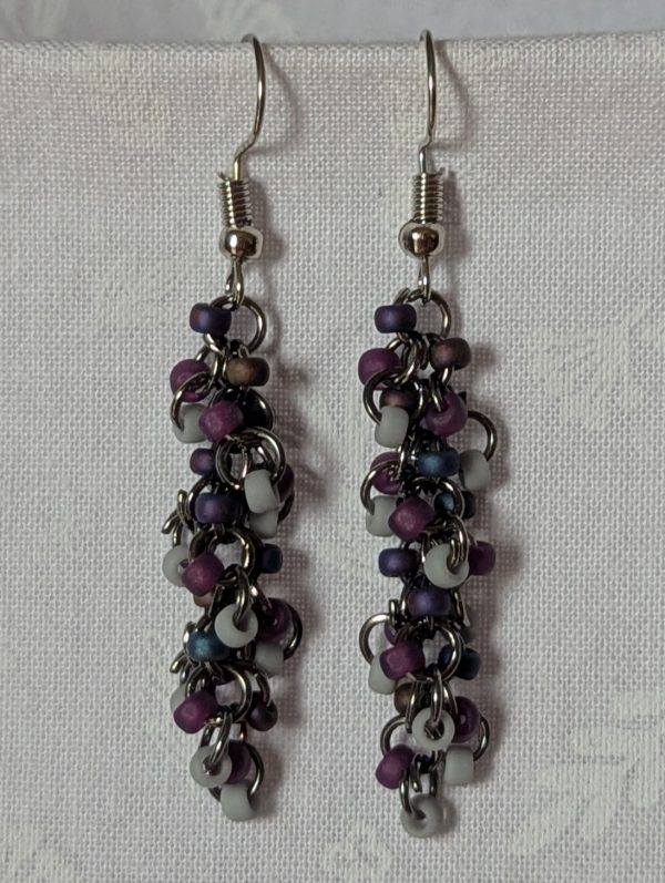 Shadow Galaxy Earrings with 27 beads in matte gray, frosted plum, and iridescent galaxy tones, linked with tungsten-colored rings and steel hooks.