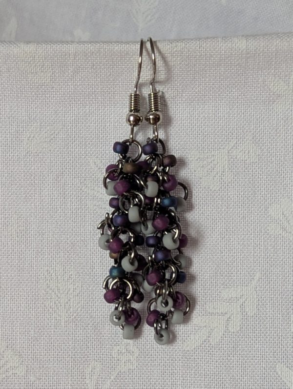 Shadow Galaxy Earrings with 27 beads in matte gray, frosted plum, and iridescent galaxy tones, linked with tungsten-colored rings and steel hooks.