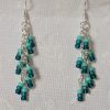 Ocean Whisper Earrings: A pair of handmade teal dangle earrings with 27 seafoam, silver-lined, and iridescent cyan beads. Suspended on silver jump rings with sterling silver hooks.