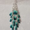 Ocean Whisper Earrings: A pair of handmade teal dangle earrings with 27 seafoam, silver-lined, and iridescent cyan beads. Suspended on silver jump rings with sterling silver hooks.