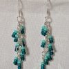 Ocean Whisper Earrings: A pair of handmade teal dangle earrings with 27 seafoam, silver-lined, and iridescent cyan beads. Suspended on silver jump rings with sterling silver hooks.