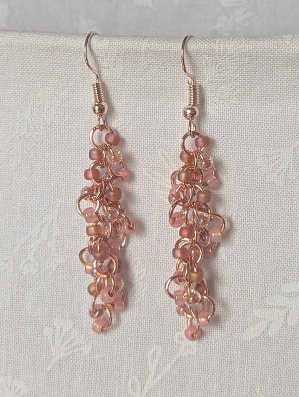 Blush Bloom Earrings with 27 soft pink glass beads in matte, translucent, and iridescent finishes, on copper rings with rose-gold earring hooks.