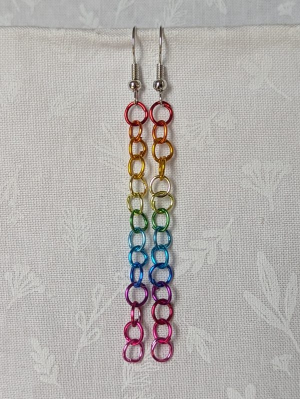 Spectrum Sleek Earrings made with 14 rainbow-colored jump rings, arranged in a smooth gradient and hung from polished steel-colored hooks.