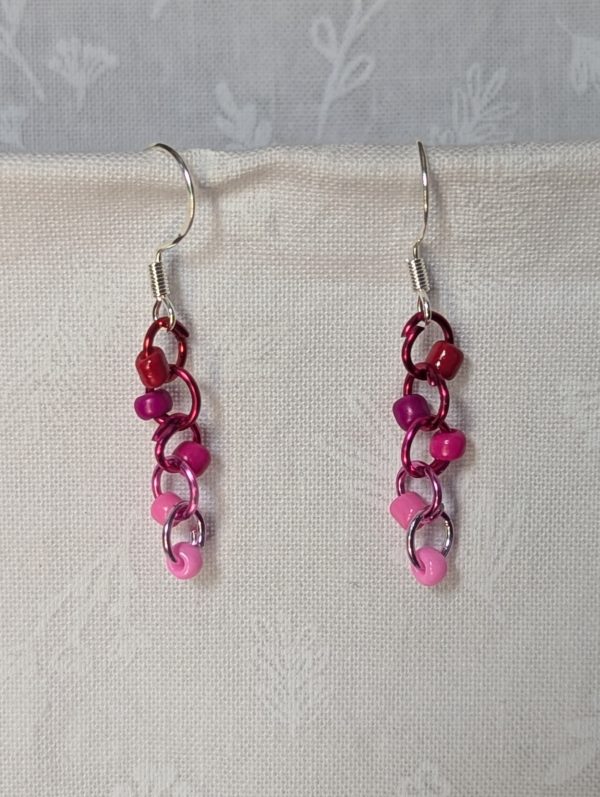 Handmade Rosy Rhapsody Earrings with five pink and red beads linked to red-to-pink gradient jump rings and sterling silver hooks.