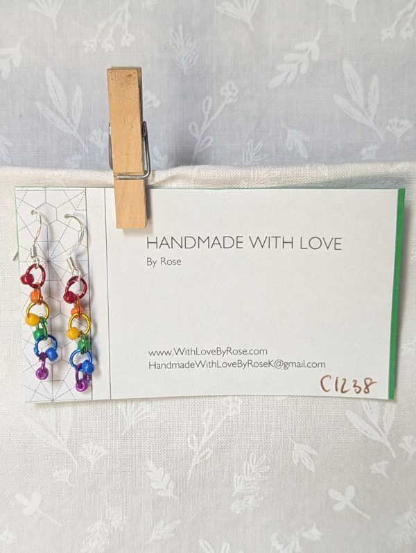 Colorful handmade Rainbow Whimsy Earrings with five bright beads on rainbow gradient jump rings and sterling silver hooks.
