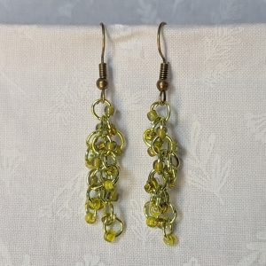 Handmade lime green earrings with 18 assorted green glass beads, lime green jump rings, and antique bronze-colored hooks.