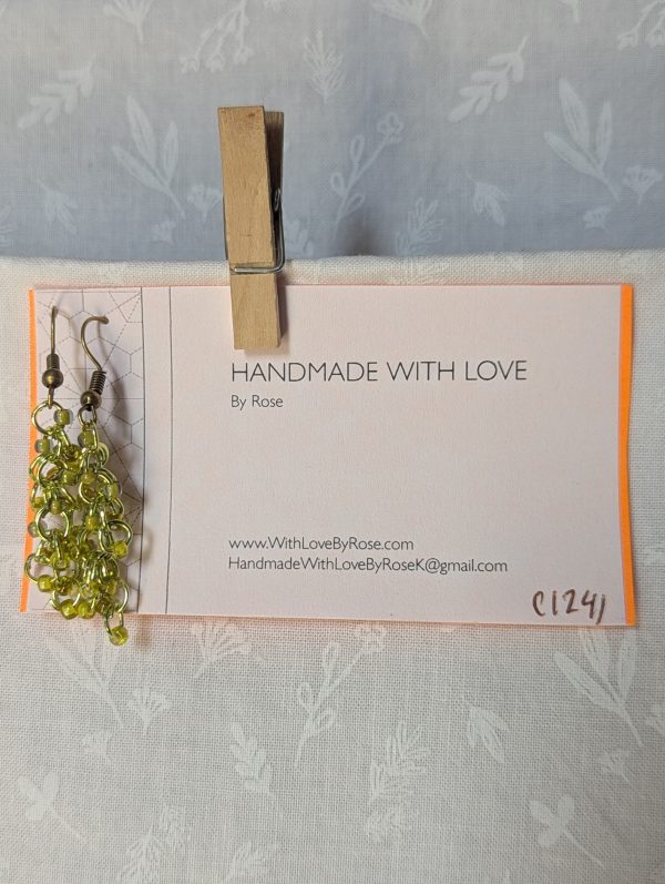 Handmade lime green earrings with 18 assorted green glass beads, lime green jump rings, and antique bronze-colored hooks.