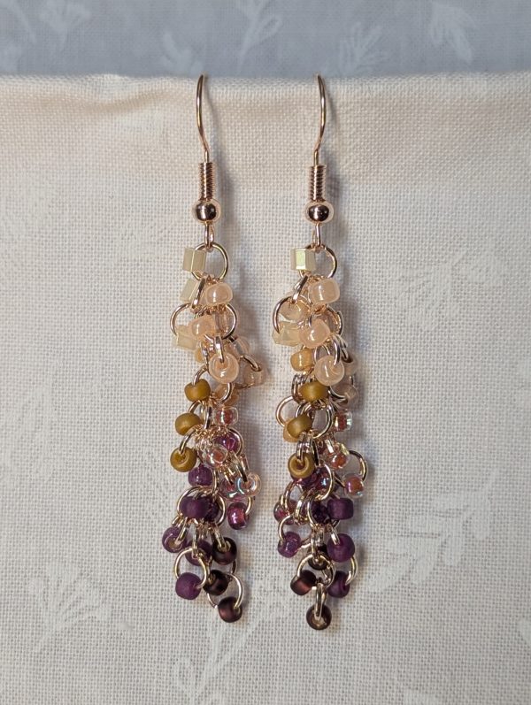 Handmade Twilight Garden earrings featuring 30 gradient beads from cream to purple on rose-gold jump rings with matching hooks.