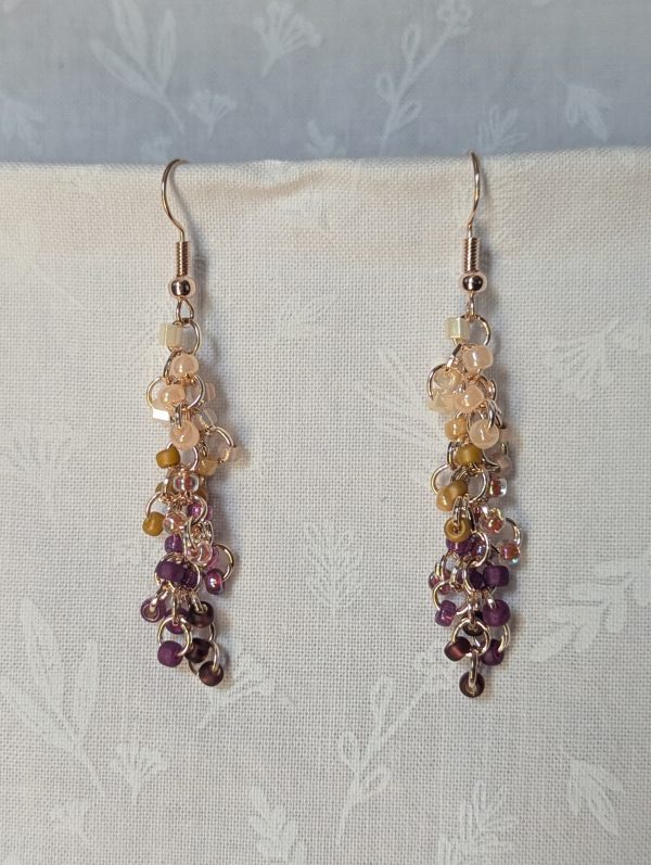 Handmade Twilight Garden earrings featuring 30 gradient beads from cream to purple on rose-gold jump rings with matching hooks.