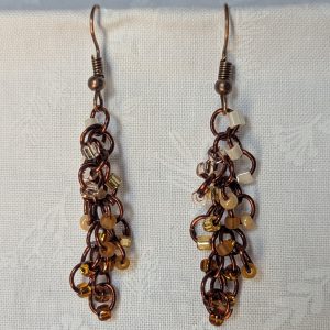 Handmade earrings with 21 gradient cream-to-brown beads on brown jump rings and antique bronze hooks.