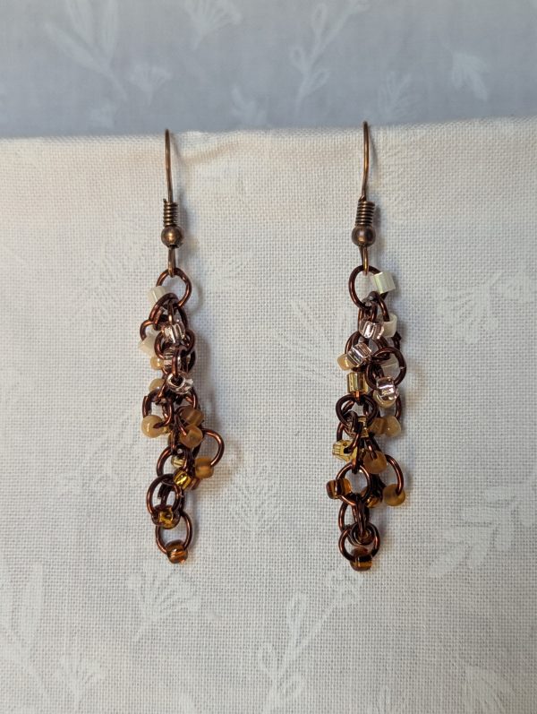 Handmade earrings with 21 gradient cream-to-brown beads on brown jump rings and antique bronze hooks.