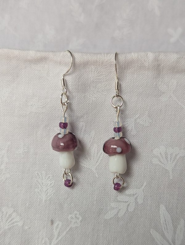 Handmade purple mushroom earrings with glass toadstools, purple and white seed beads, and sterling silver hooks.