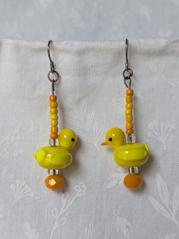 Handmade duck earrings with yellow glass duck beads, orange and yellow seed beads, Czech orange bead, and clear accents on titanium hooks.
