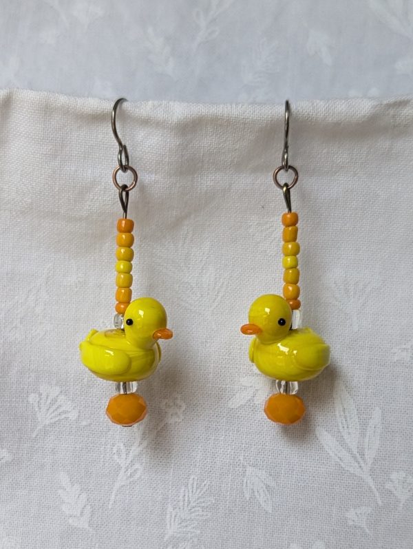 Handmade duck earrings with yellow glass duck beads, orange and yellow seed beads, Czech orange bead, and clear accents on titanium hooks.